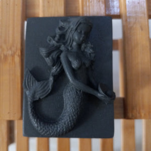 black mermaid holding a pearl activated charcoal and tea tree oil goats milk soap