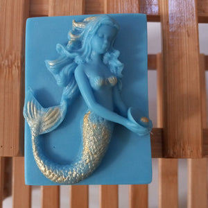 blue mermaid holding a golden pearl, goats milk soap scented with plumeria