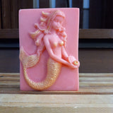 pink mermaid holdind a golden pearl goats milk soap scented with red poppy fragrance