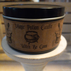 witch be gone beeswax candle in black travel tin with craft label with cauldron and witch flying away in a basket
