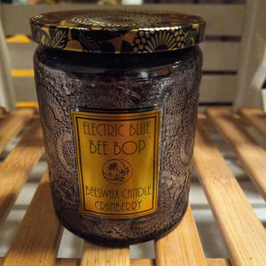 carnberry scented beeswax candle in dark gray embossed glass with black and gold tin lid