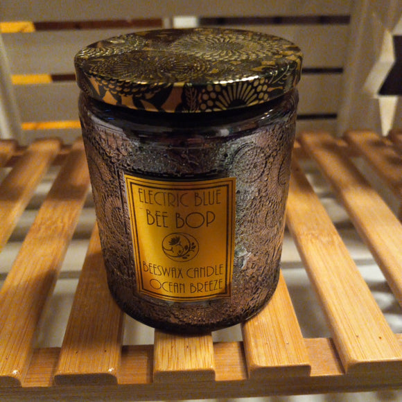ocean breeze scented beeswax candle in dark gray embossed glass with black and gold tin lid