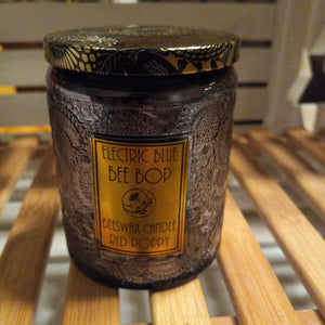 beeswax candle in dark gray embossed glass with black and gold tin lid red poppy fragrance