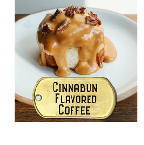 Cinnabun flavored coffee pictured with cinnamon roll oozing with caramel