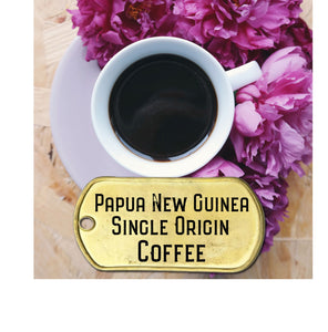 Papua New Guinea single origin coffee in a cup surrounded by flowers