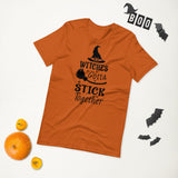 witches gotta stick together black lettering on orange tshirt with witch hat and broomstick